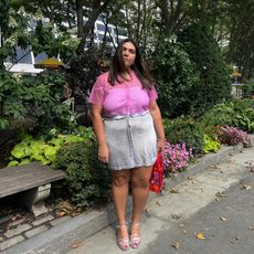 Woman wearing a pink top and metallic skirt from the MNZ x J. Crew
